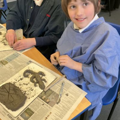 Children making clay lizards